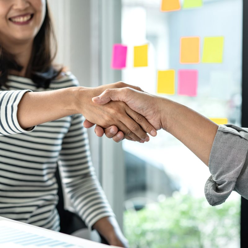 Businessman shaking hands with businesswoman after discussing good deal of Trading contract and new project.